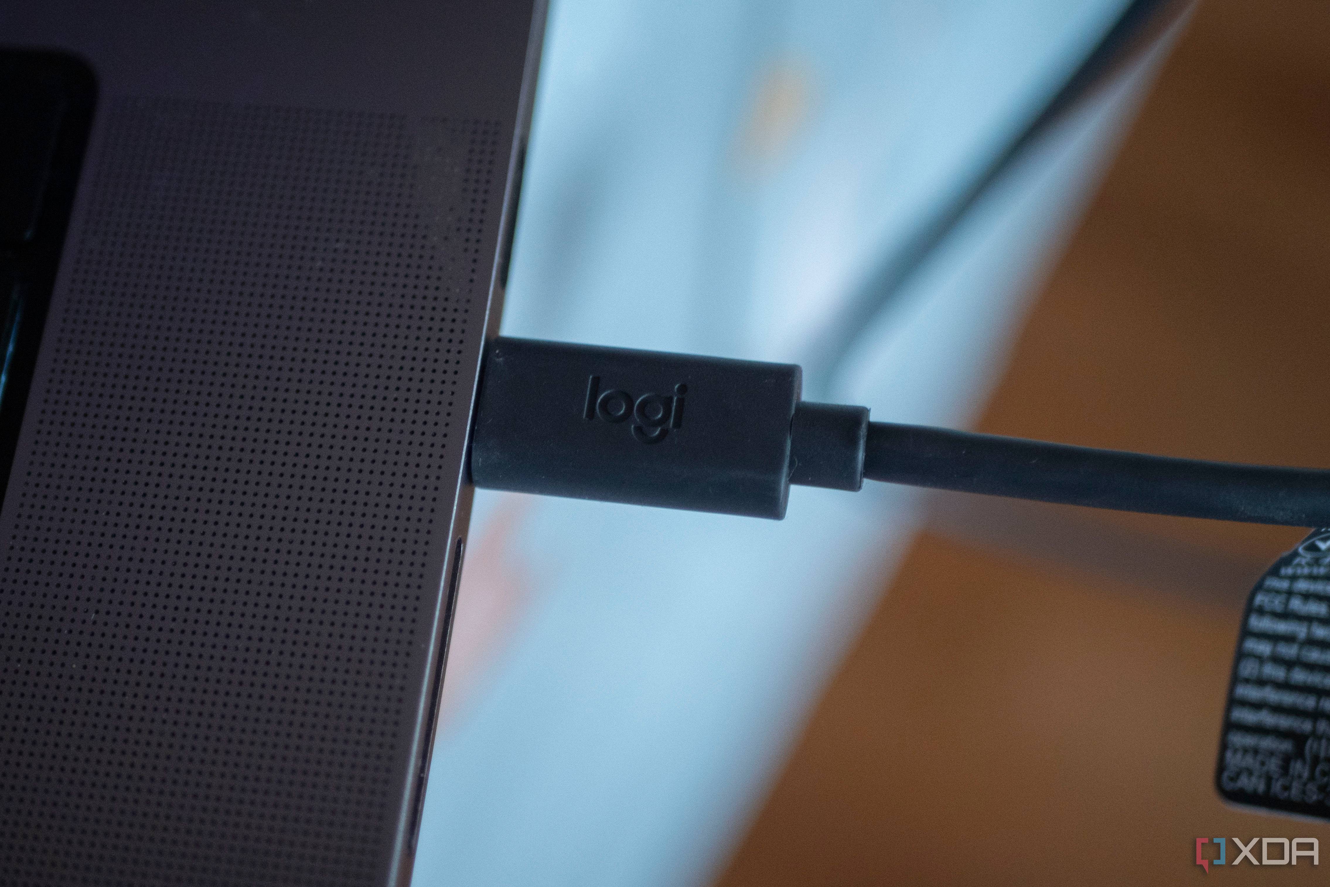 Logitech StreaCam USB-C connector plugged into a laptop, with "Logi" inscribed in it