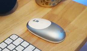 A blue M1 mouse on a desk with a keyboard.