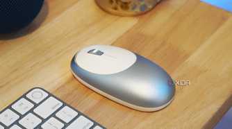 A blue M1 mouse on a desk with a keyboard.