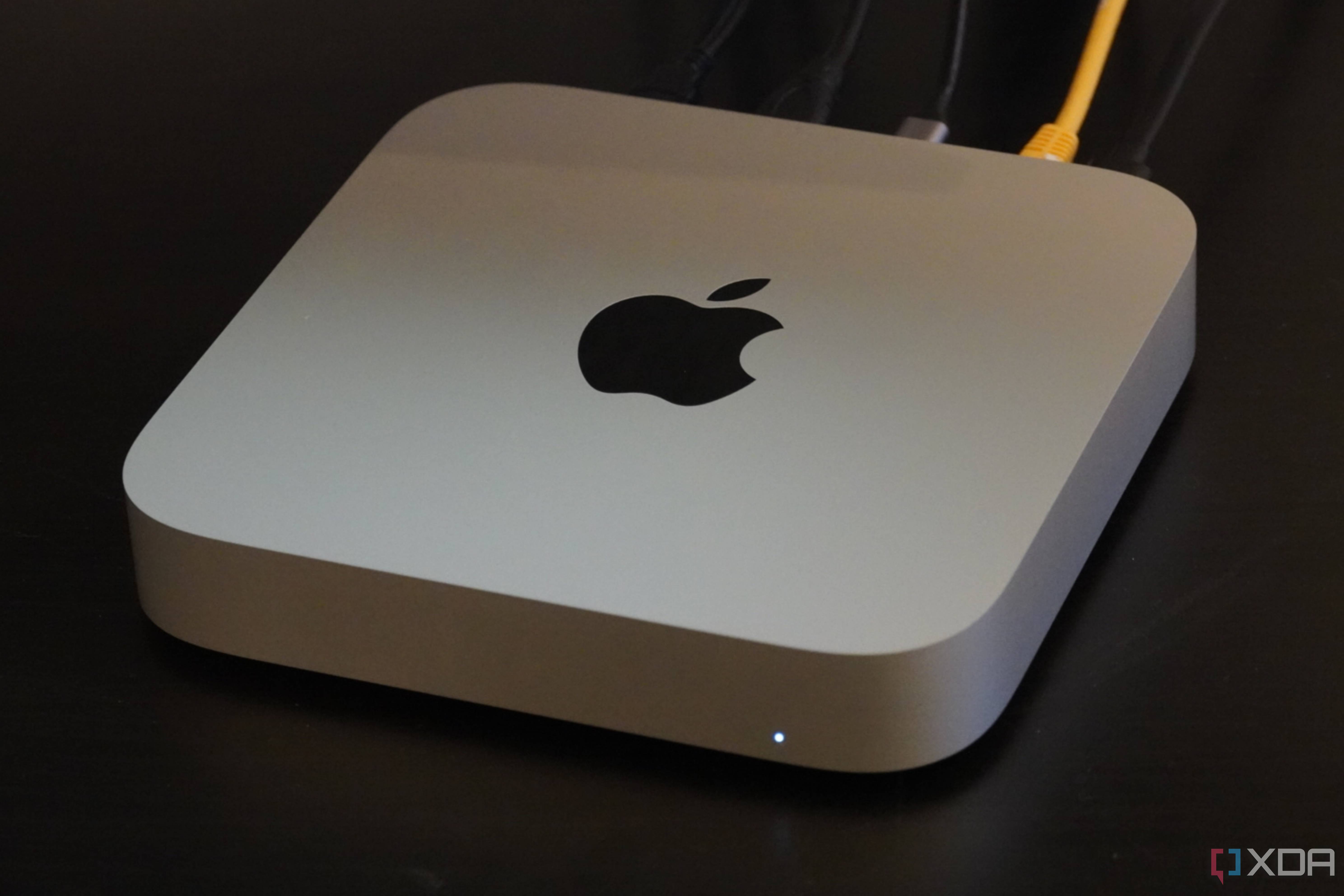 A Mac Mini on a desk with cables connected.