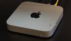 A Mac Mini on a desk with cables connected.