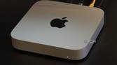 A Mac Mini on a desk with cables connected.
