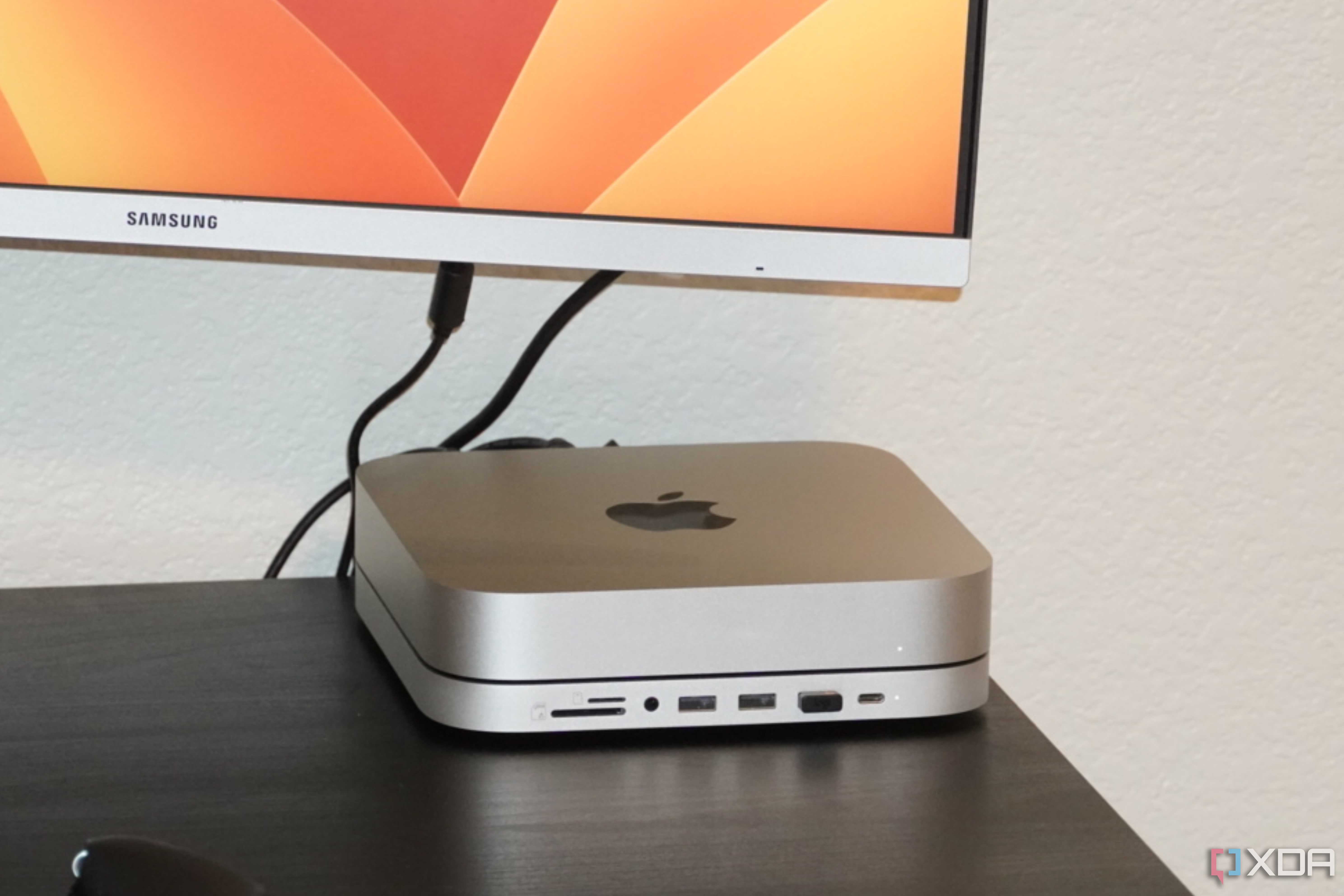 A Mac Mini with a macOS wallpaper in the background.