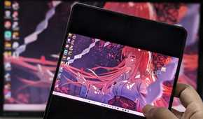 An image showing a person holding a phone displaying the Moonlight app running desktop mirror.