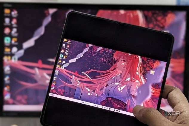 An image showing a person holding a phone displaying the Moonlight app running desktop mirror.