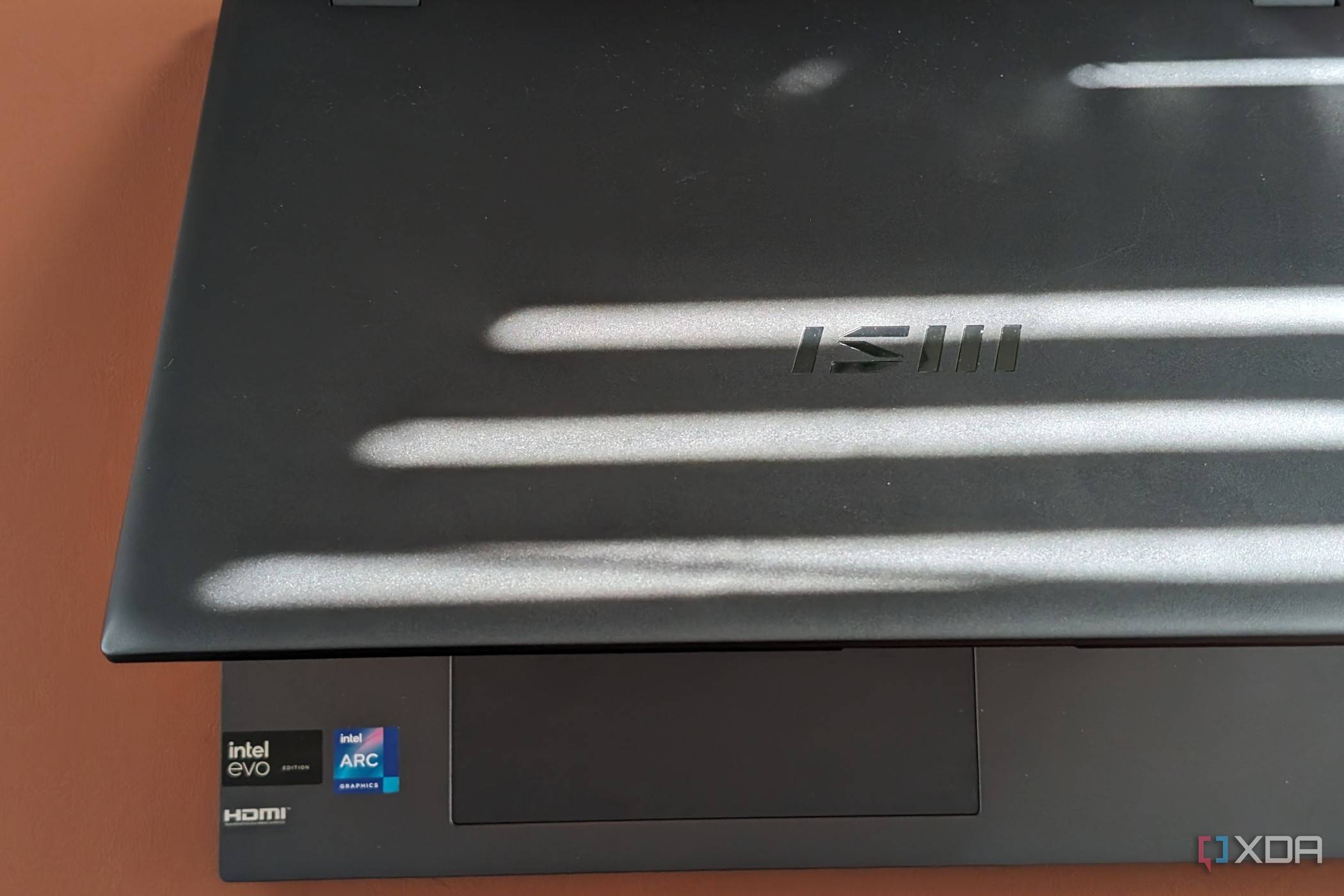 A photo of the MSI Prestige Evo 16 AI lid open with the MSI branding and Intel branding stickers showing