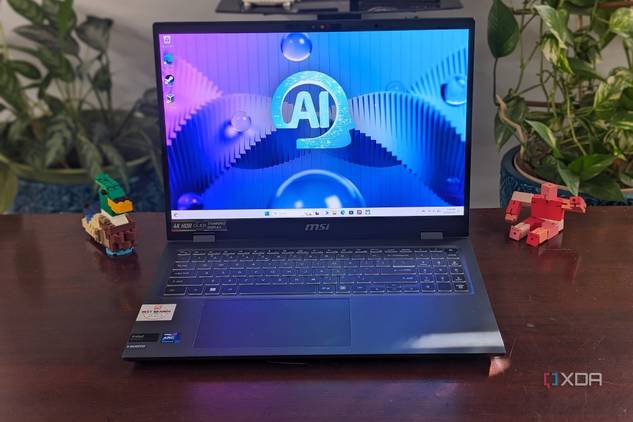 A photo of the MSI Prestige Evo 16 AI sitting on a desk with plants and toy objects in the background