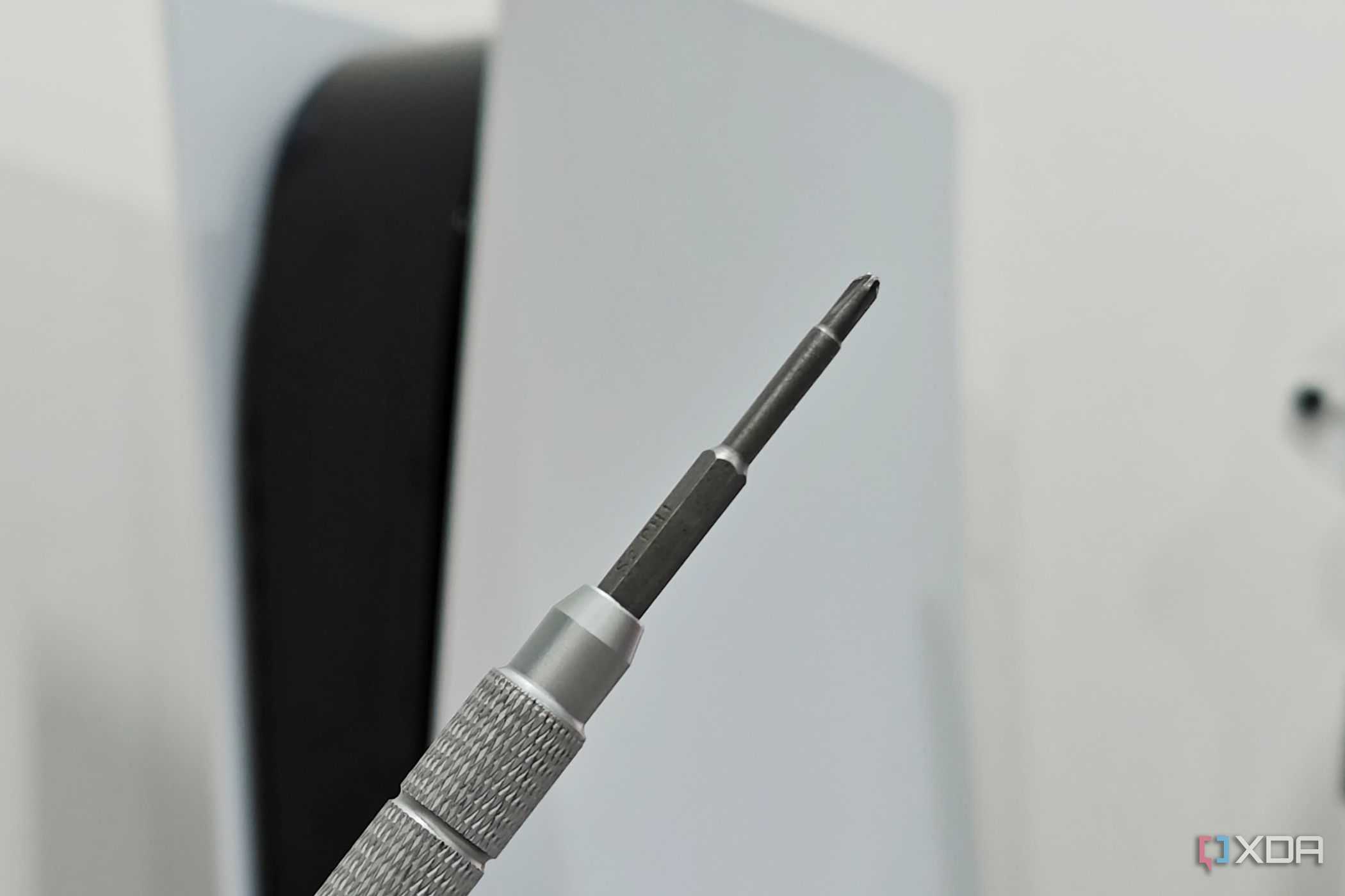 An image showing a Philips head screwdriver with a PS5 in the background.