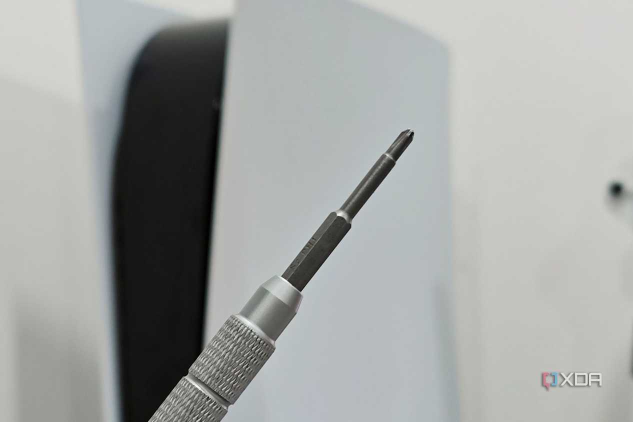 An image showing a Philips head screwdriver with a PS5 in the background.