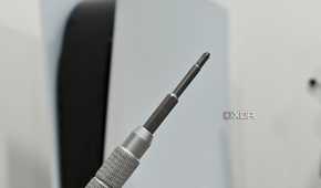 An image showing a Philips head screwdriver with a PS5 in the background.