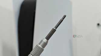 An image showing a Philips head screwdriver with a PS5 in the background.
