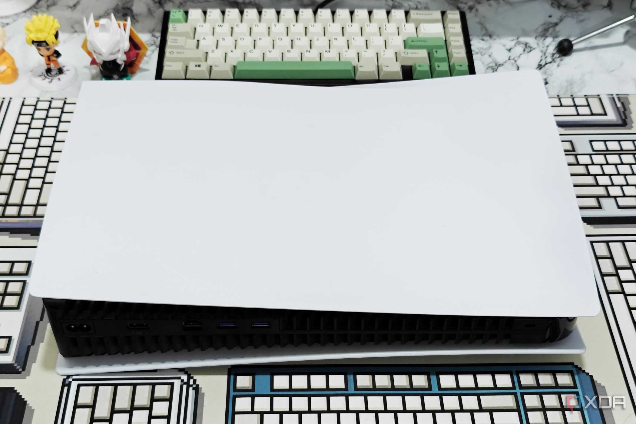 An image showing a PS5 laying flat on a table with a CRP deskmat.