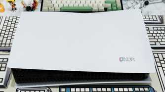An image showing a PS5 laying flat on a table with a CRP deskmat.