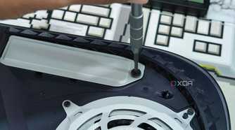 An image showing a person unscrewing the PS5 SSD slot cover.