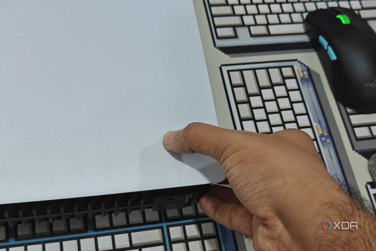 An image showing a person trying to remove PS5 side panel.