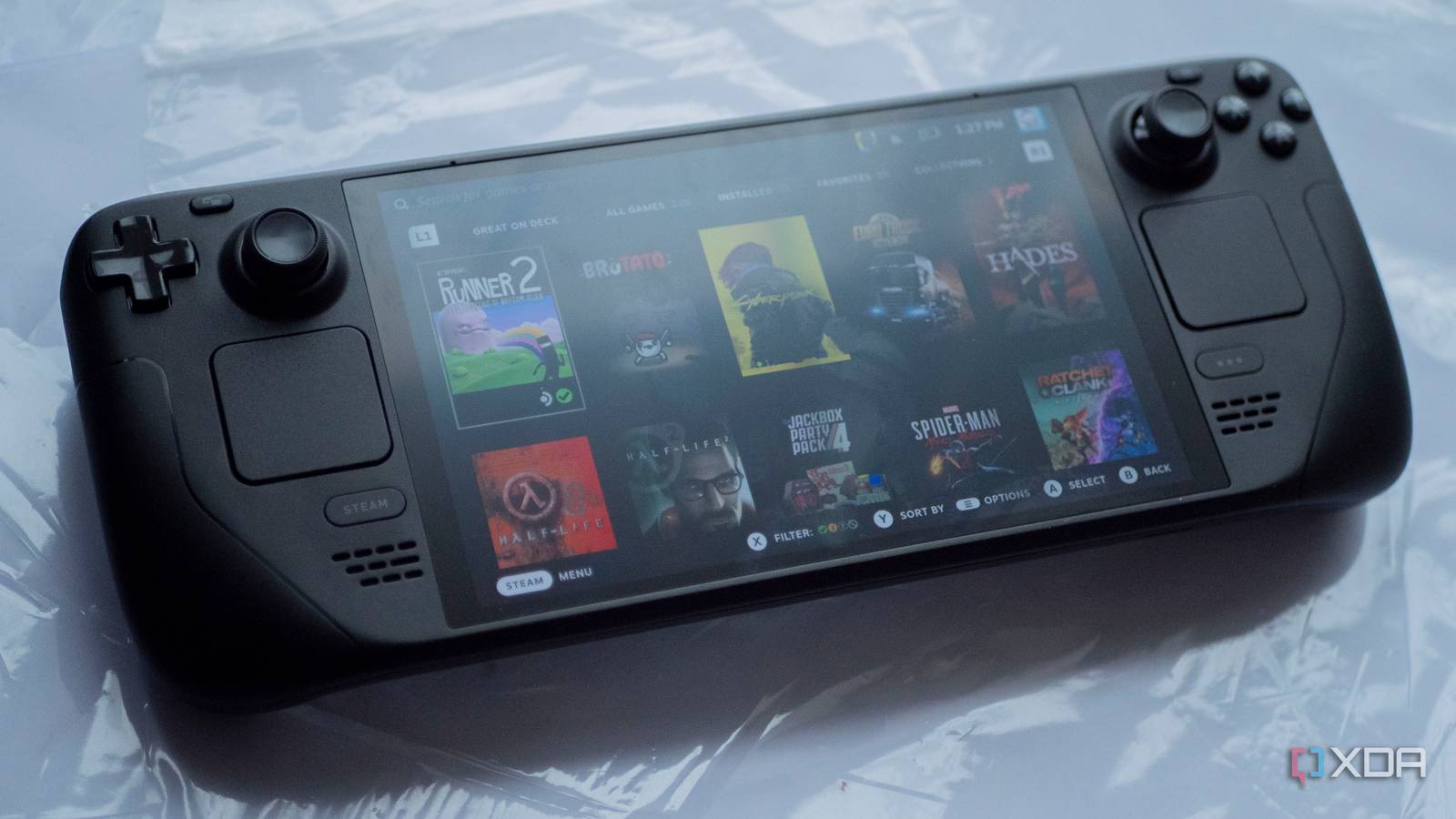 Image of Steam Deck OLED model lying on table displaying multiple games.