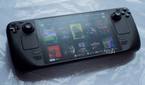 Image of Steam Deck OLED model lying on table displaying multiple games.
