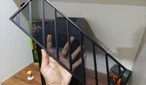 An image showing a person holding the front mesh panel with a PC case and a desk in the background.