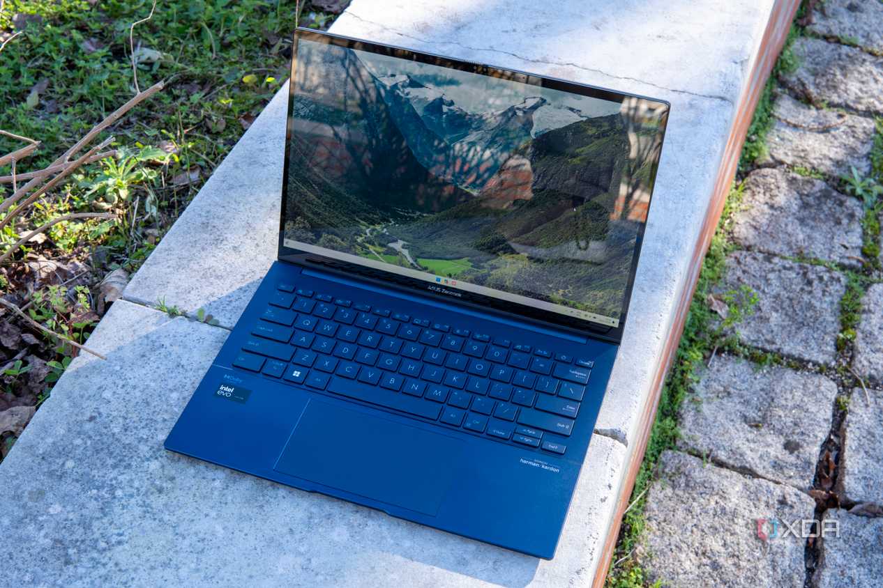 Asus Zenbook 14 OLED laptop open on a brick wall