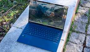 Asus Zenbook 14 OLED laptop open on a brick wall