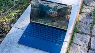 Asus Zenbook 14 OLED laptop open on a brick wall