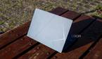 Rear angled view of the Asus Zenbook 14 OLED reflecting harsh sunlight