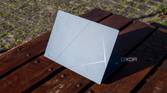Rear angled view of the Asus Zenbook 14 OLED reflecting harsh sunlight