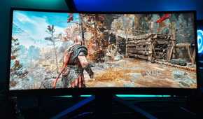 An image showing a Benq ultrawide gaming monitor kept on a desk with RGB lights on the background.