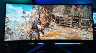 An image showing a Benq ultrawide gaming monitor kept on a desk with RGB lights on the background.