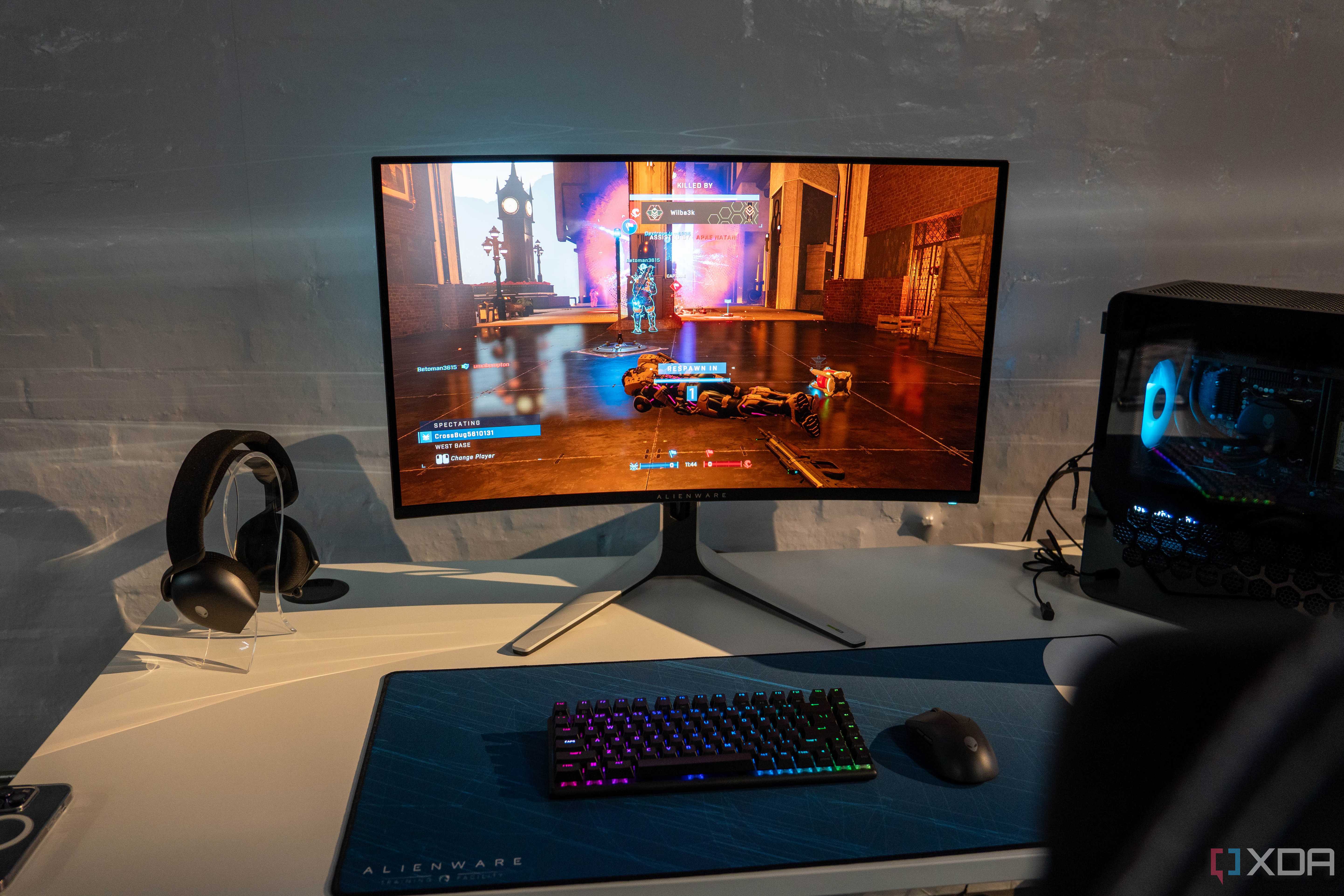 Dell QD-OLED monitor on a desk next to PC hardware