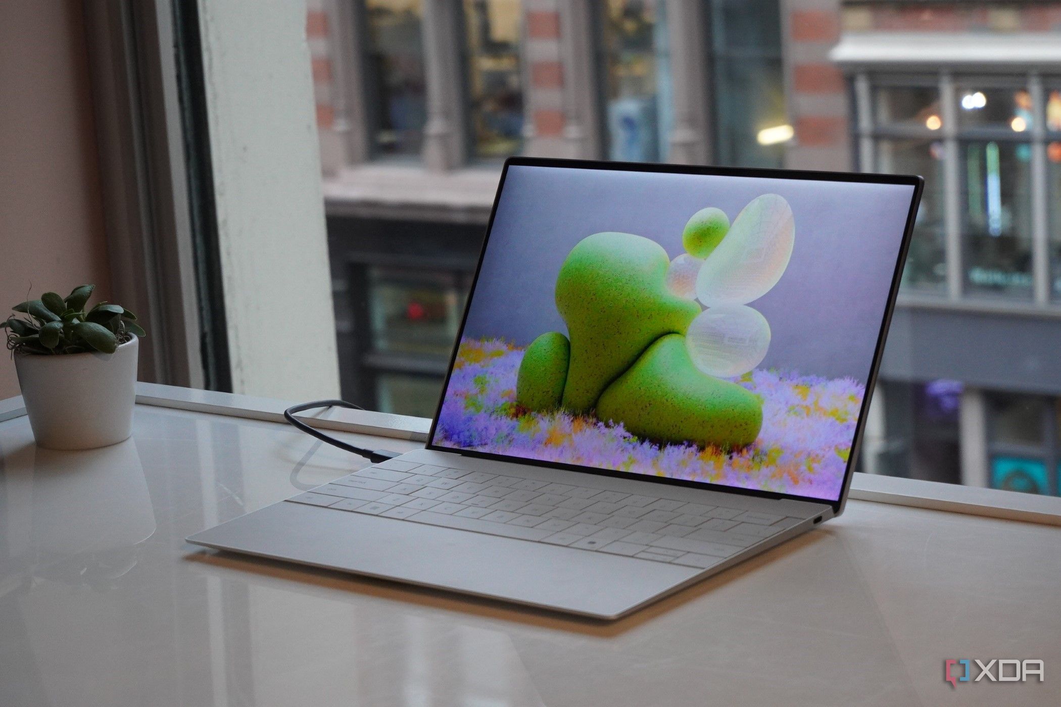 Dell XPS 13 (2024) on a table in front of a window.