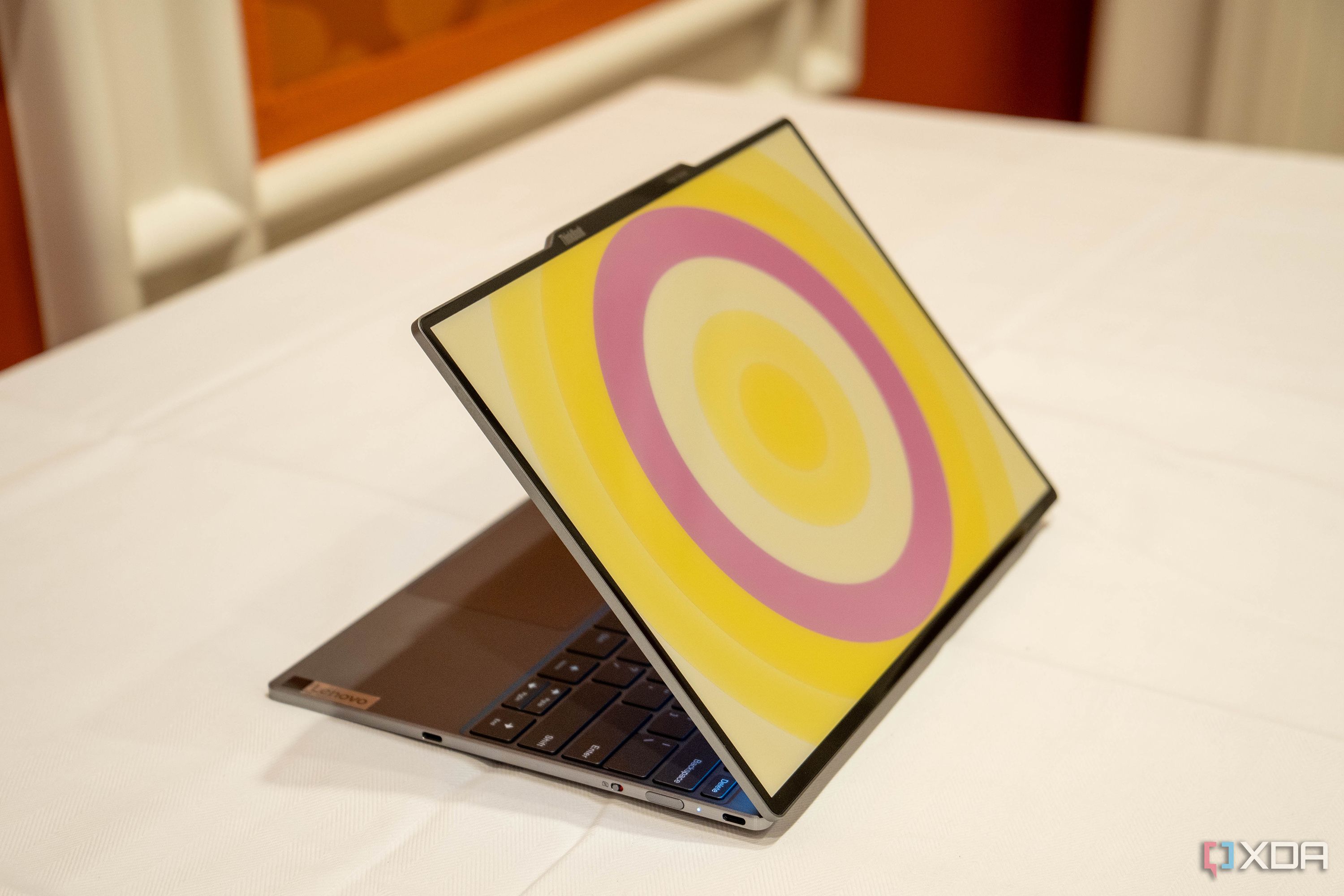 Angled view of the Lenovo ThinkBook 13x Gen 4 SPE showing a circular patter in yellow and pink on the lid