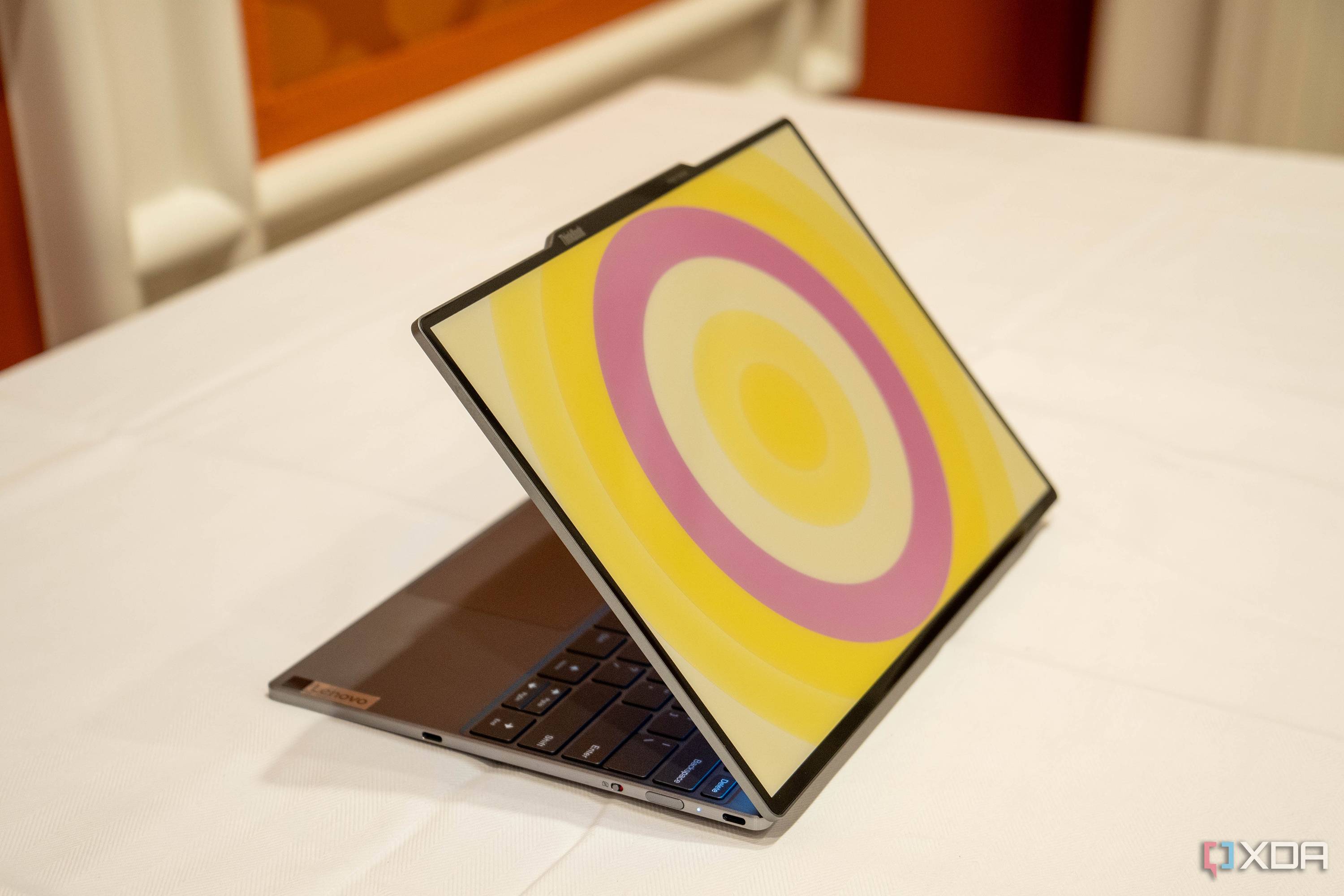 Angled view of the Lenovo ThinkBook 13x Gen 4 SPE showing a circular patter in yellow and pink on the lid
