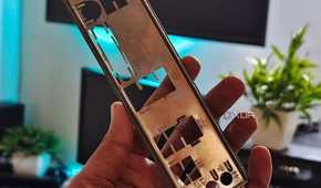 An image showing a person holding a motherboard IO plate in their hand.