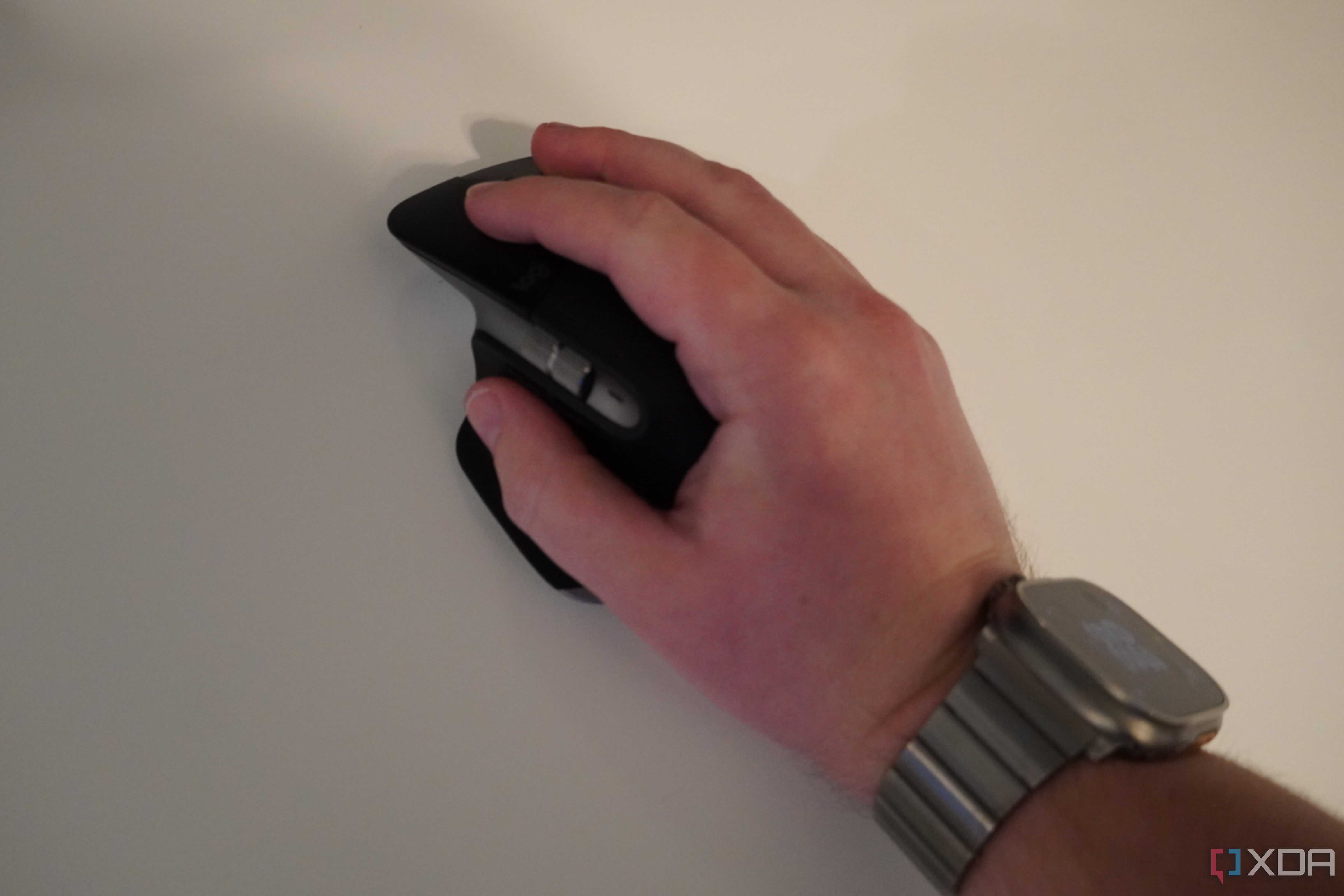 A hand resting on the MX Master 3 mouse.