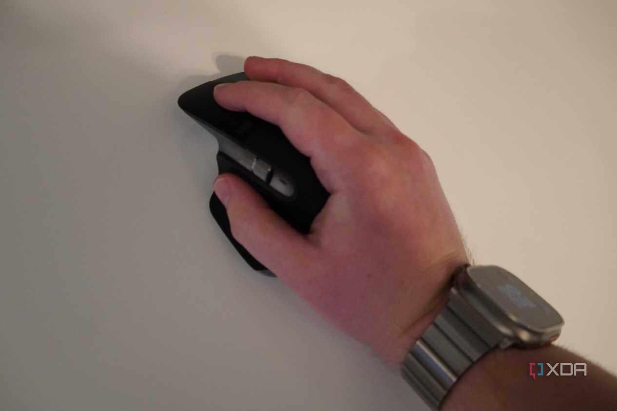 A hand resting on the MX Master 3 mouse.