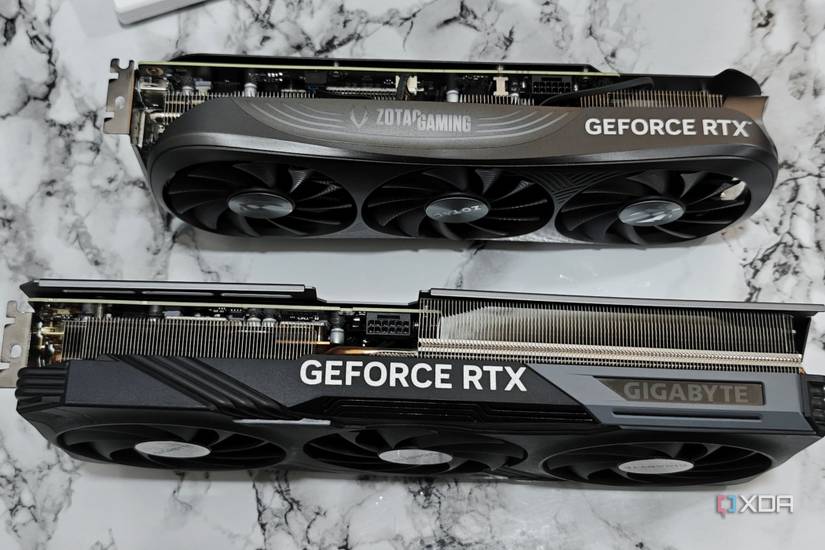 An image showing a Zotac Gaming RTX 4070 Super GPU kept next to Gigabyte RTX 4070 Ti Gaming OC GPU for size comparison.