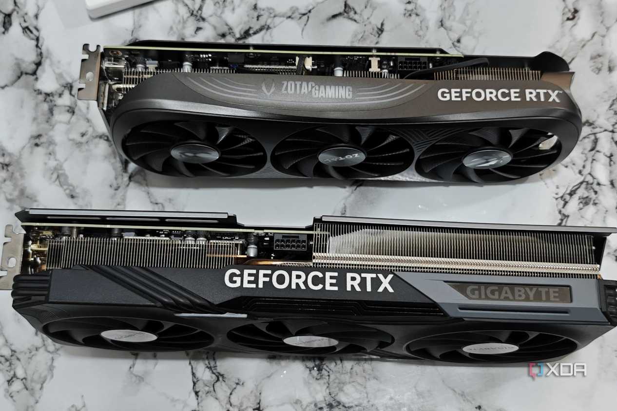 An image showing a Zotac Gaming RTX 4070 Super GPU kept next to Gigabyte RTX 4070 Ti Gaming OC GPU for size comparison.