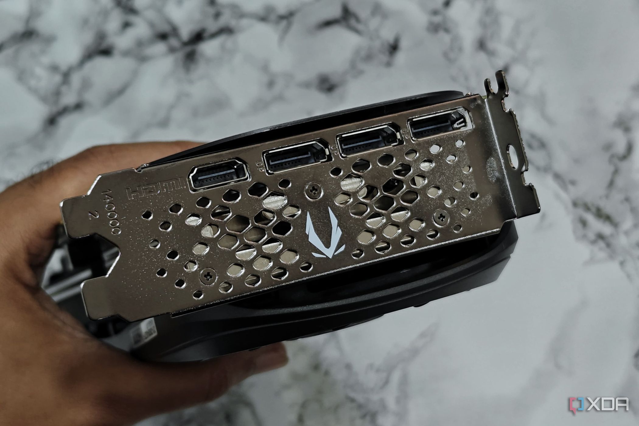 An image showing a person holding the Zotac Gaming GeForce RTX 4070 Super to show its ports at the rear.