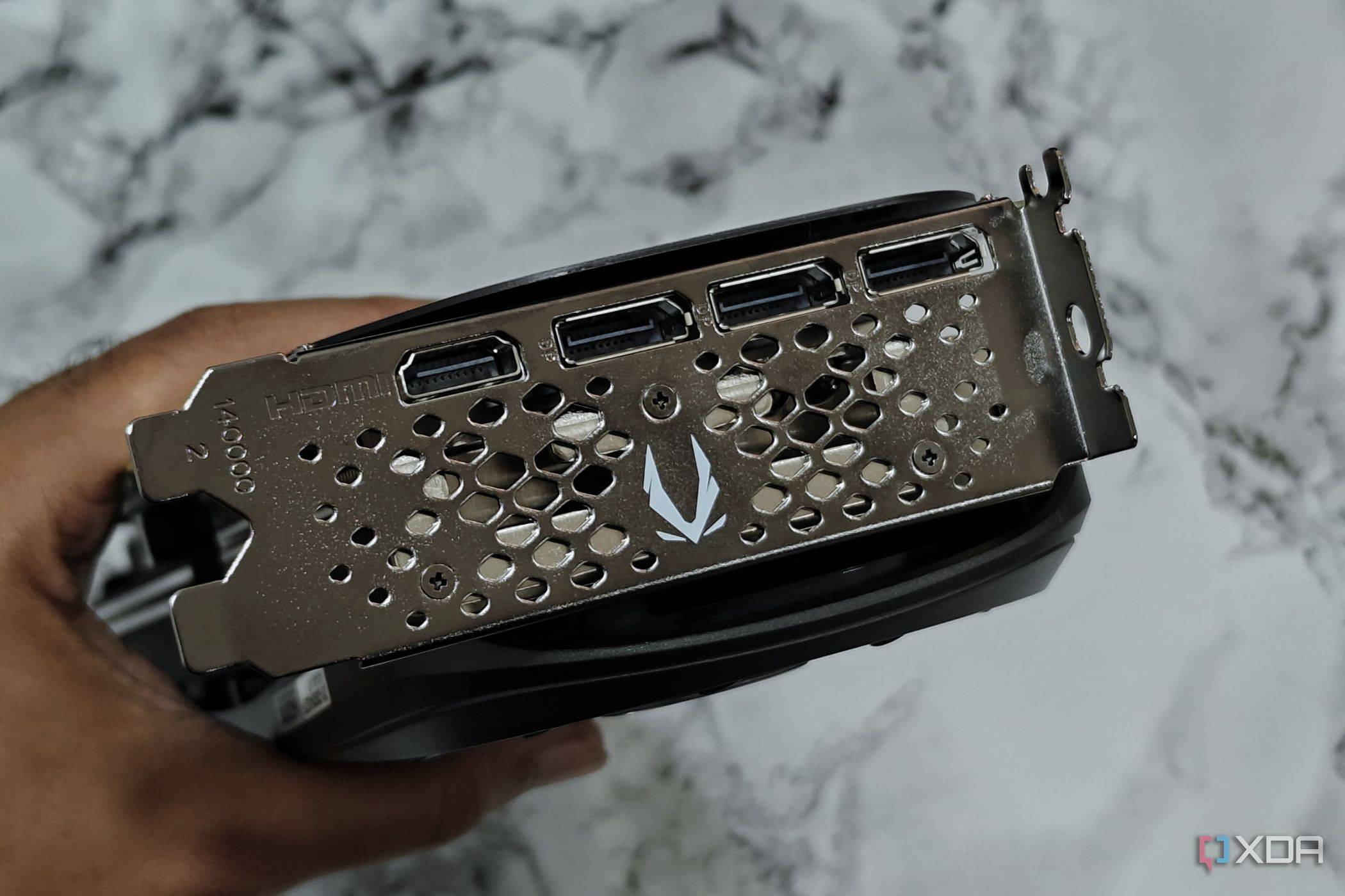 An image showing a person holding the Zotac Gaming GeForce RTX 4070 Super to show its ports at the rear.
