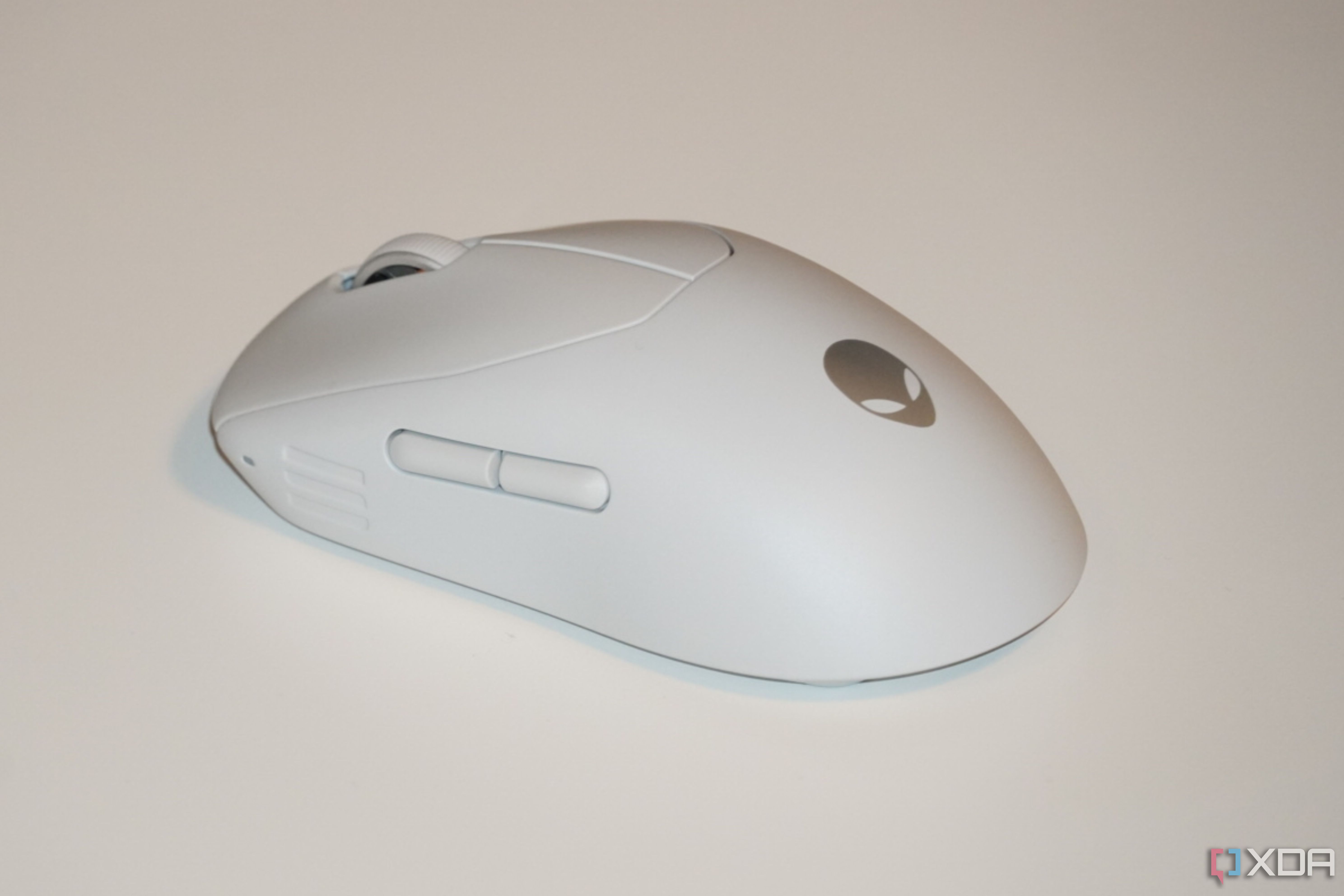The white Alienware Pro Gaming Mouse on a white desk.
