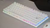 The Alienware Pro wireless keyboard on a desk with RGB lighting.