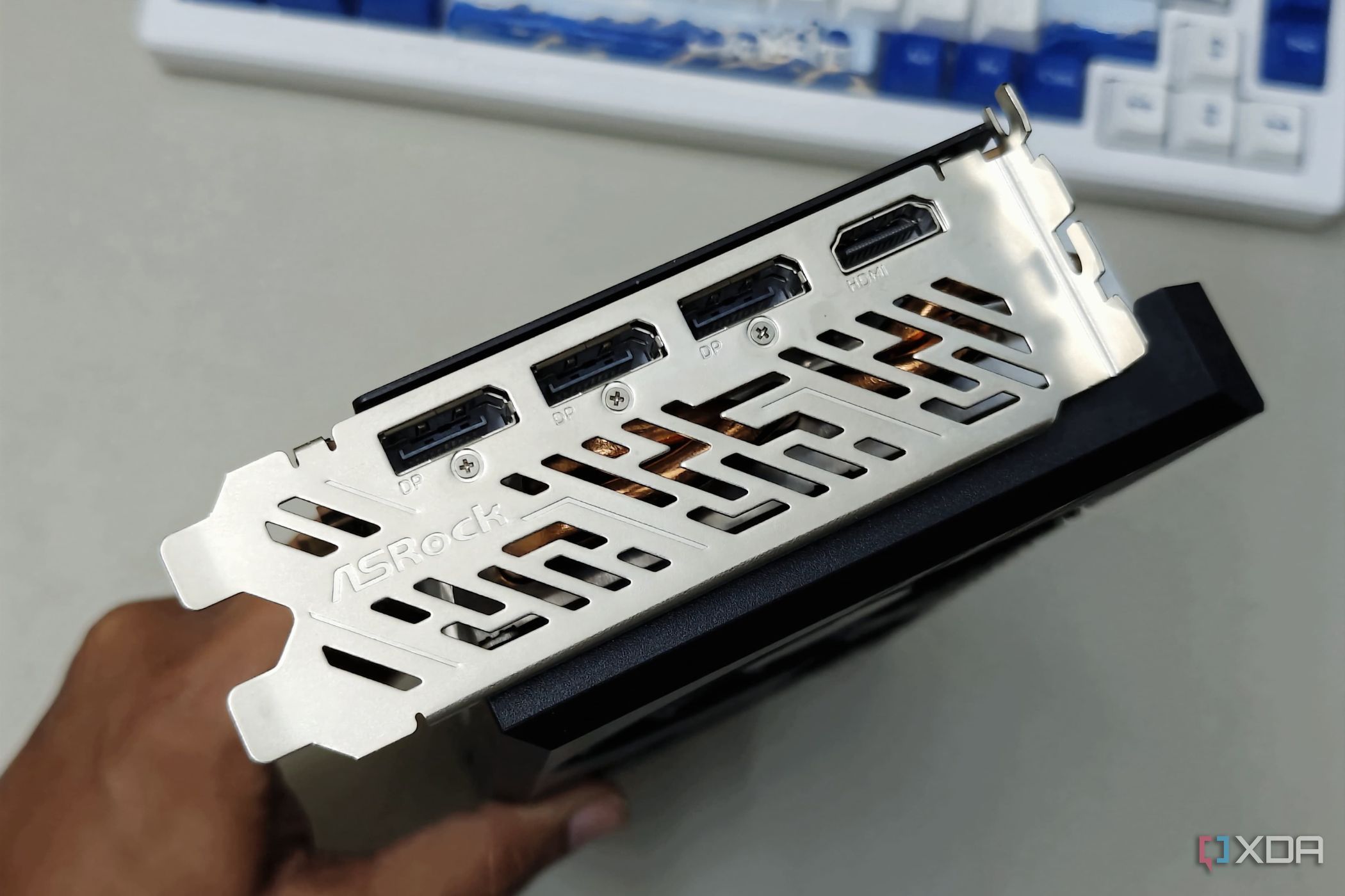 An image showing the IO shroud and ports of the ASRock RX 7700 XT GPU.