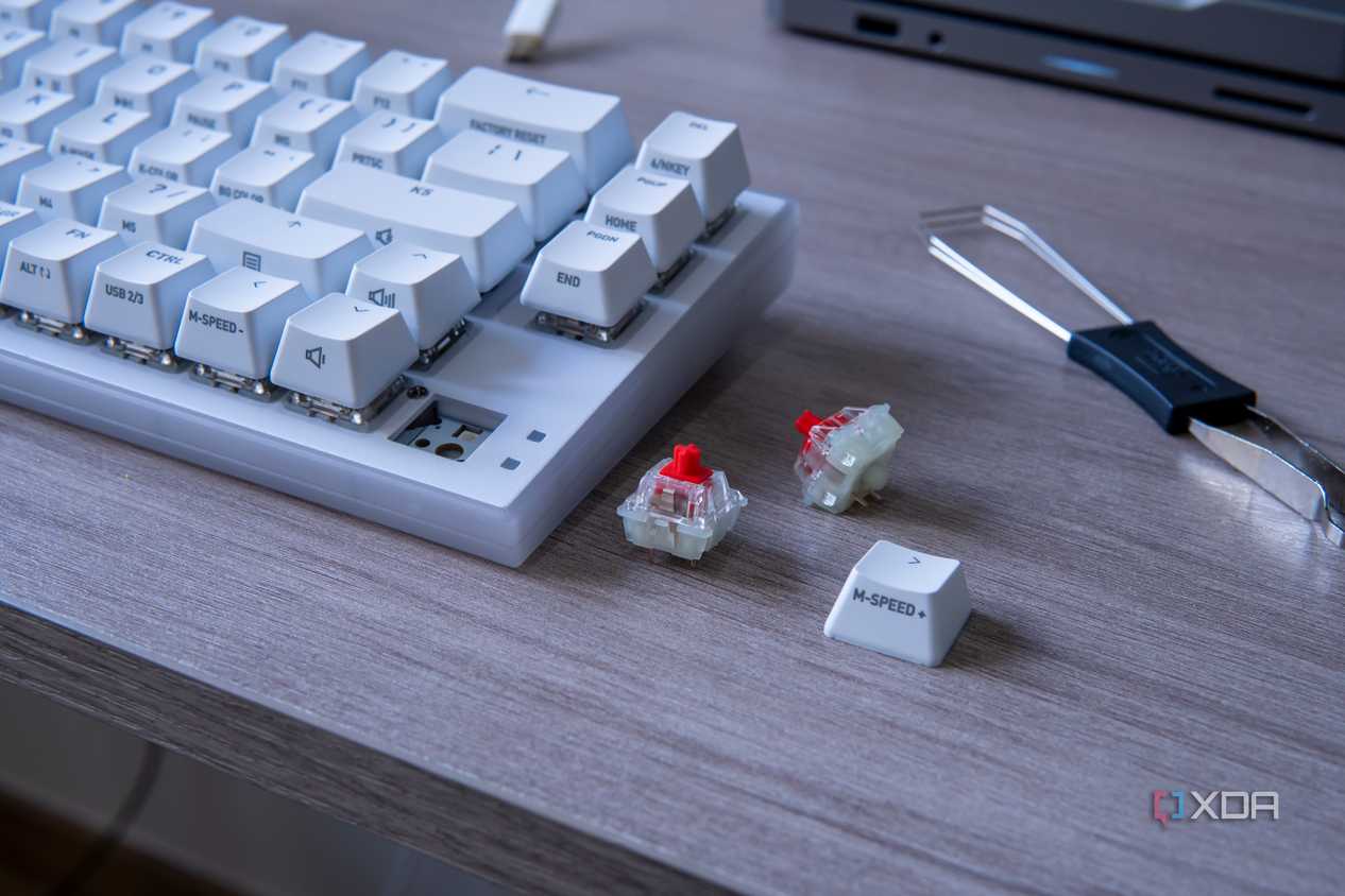 A Cherry Xtrfy K5V2 with a couple of switches and a keycap next to it