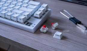 A Cherry Xtrfy K5V2 with a couple of switches and a keycap next to it