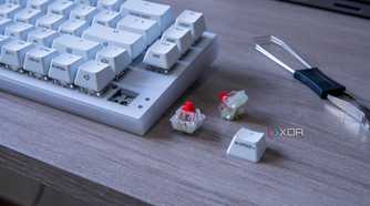 A Cherry Xtrfy K5V2 with a couple of switches and a keycap next to it