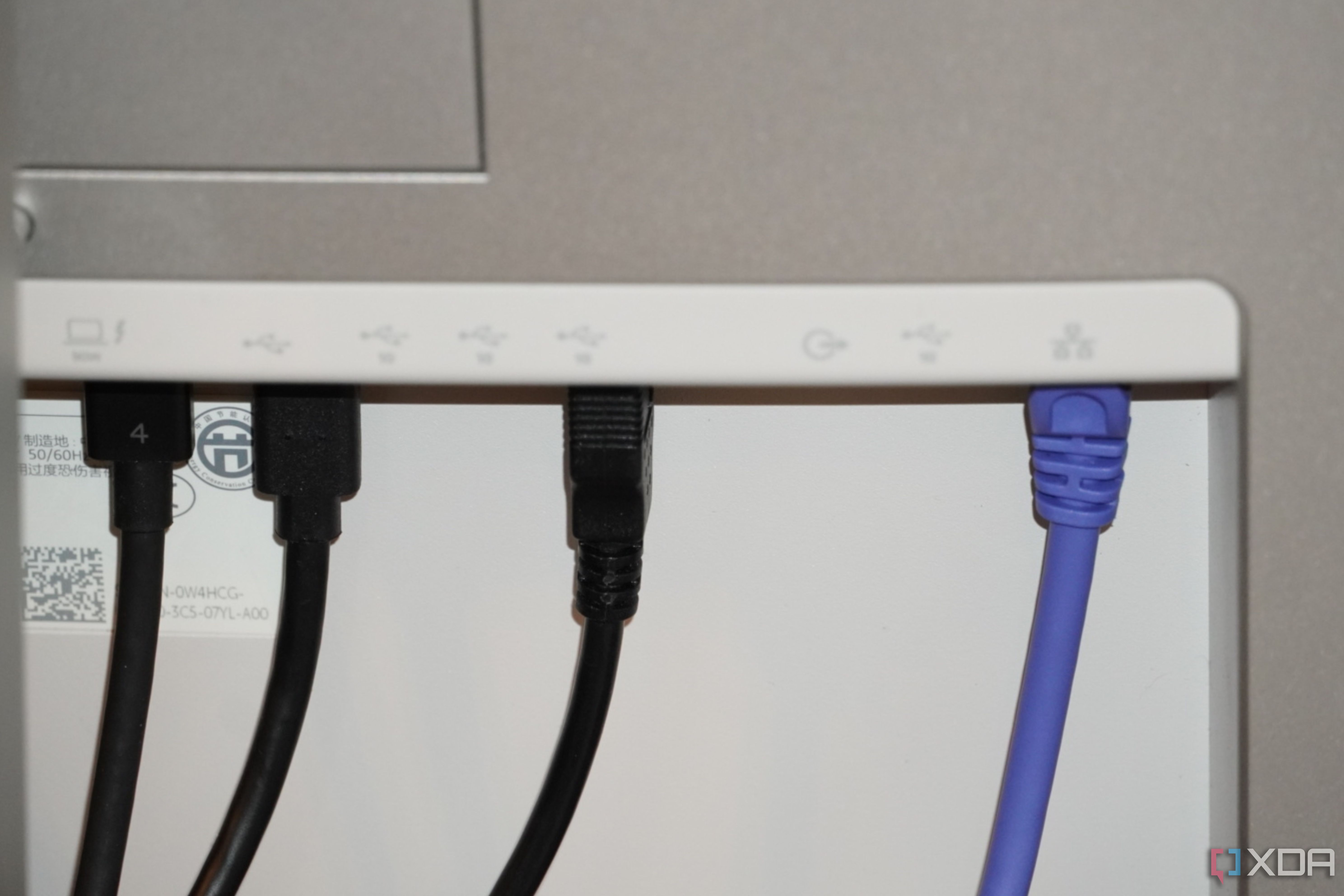 Ethernet and USB cables coming out of the back of a Dell UltraSharp monitor.