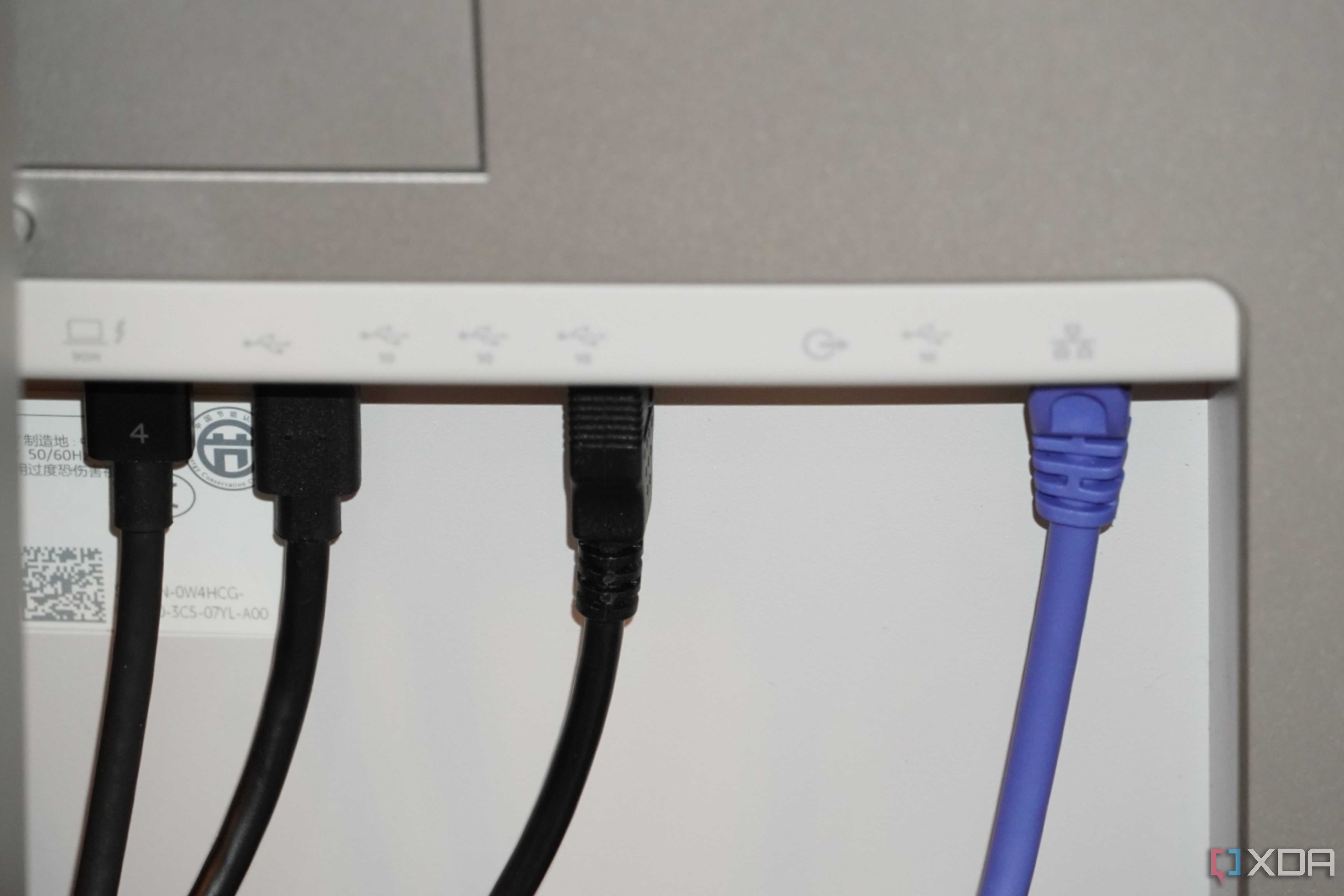 Ethernet and USB cables coming out of the back of a Dell UltraSharp monitor.