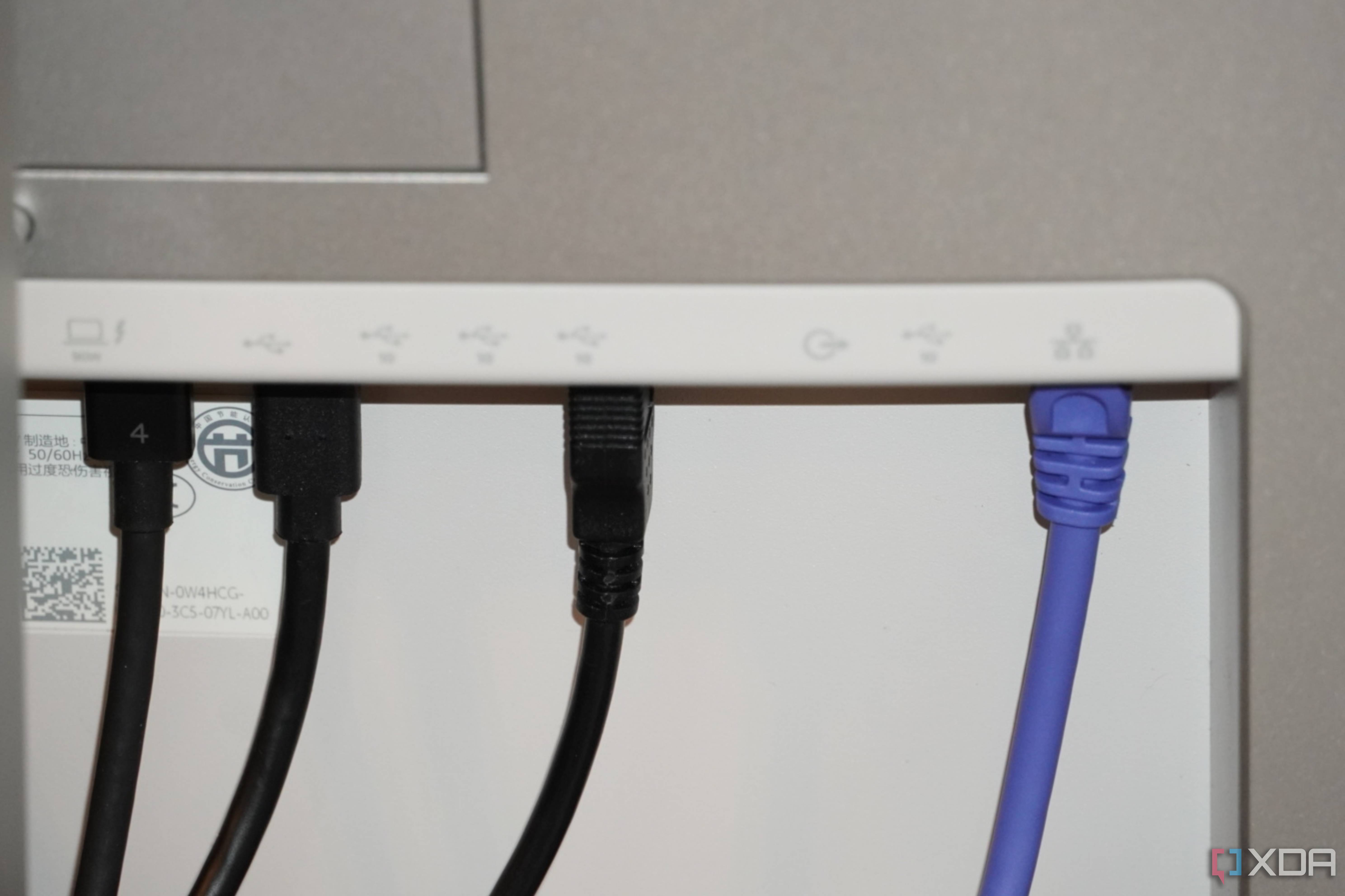 Ethernet and USB cables coming out of the back of a Dell UltraSharp monitor.