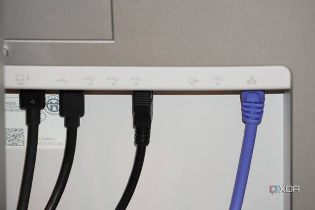 Ethernet and USB cables coming out of the back of a Dell UltraSharp monitor.
